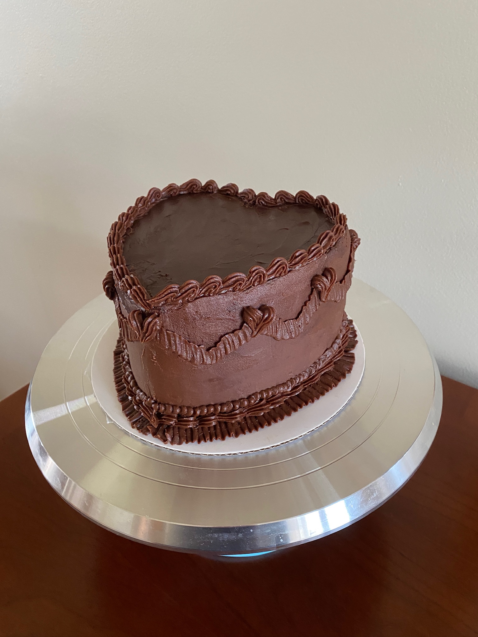 A decorated chocolate cake in the shape of a heart.